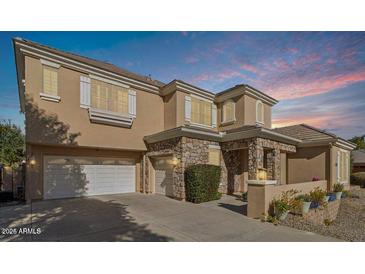 Two-story house with stone accents and a three-car garage at 950 E Desert Inn Dr, Chandler, AZ 85249