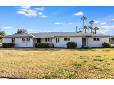 White brick ranch house with a spacious lawn and mature trees at 1905 W Cambridge Ave, Phoenix, AZ 85009