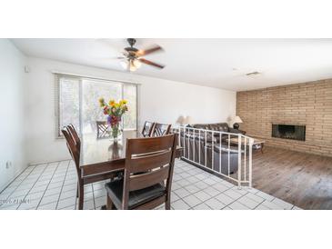 Bright dining room with wood table and chairs, adjacent to living room with fireplace at 3433 W Mescal St, Phoenix, AZ 85029