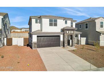 Charming two-story home with a two-car garage and stone accents enhancing curb appeal under a clear blue sky at 7396 W Whitehorn Trl, Peoria, AZ 85383