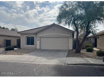 Tan two-car garage home with front yard landscaping at 4051 W Buckskin Trl, Phoenix, AZ 85083