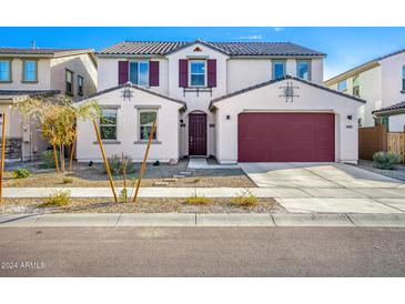 Two-story house with red garage door and landscaping at 14271 W Alameda Rd, Surprise, AZ 85387