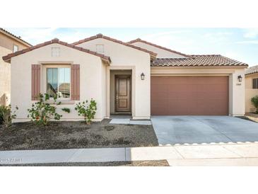 Single-story home with two-car garage, neutral color palette, and landscaping at 17849 W Thistle Landing Dr, Goodyear, AZ 85338