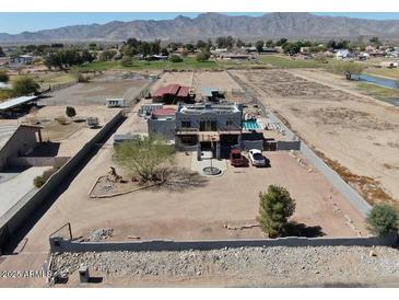 Expansive aerial view of desert property with custom home, pool, horse facilities, and mountain views at 7214 N 183Rd Ave, Waddell, AZ 85355