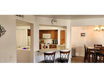 Well-equipped kitchen featuring wood cabinets and a breakfast bar at 1331 W Baseline Rd # 260, Mesa, AZ 85202