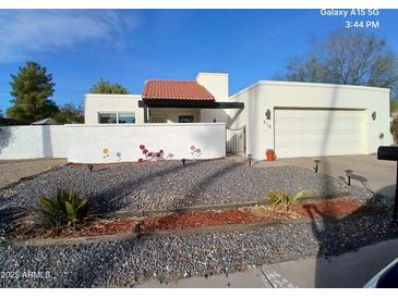 Single story home with landscaped front yard and attached garage at 618 E Piping Rock Rd, Phoenix, AZ 85022