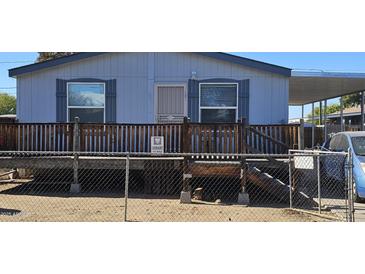 Single-wide manufactured home with wooden deck and fenced yard at 18002 N 20Th N Pl, Phoenix, AZ 85022