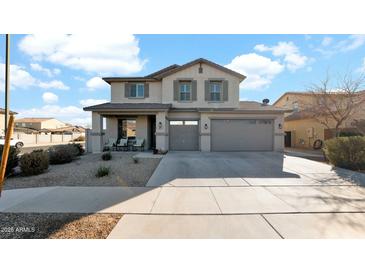 Two-story house with gray siding, a three-car garage, and a landscaped front yard at 18225 W Foothill Dr, Surprise, AZ 85387