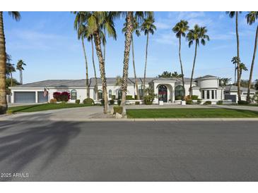 Stunning white exterior with palm trees and a circular driveway at 8500 E Aster Dr, Scottsdale, AZ 85260