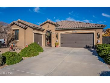 Single-story home with a two-car garage and landscaped front yard at 16140 W Almeria Rd, Goodyear, AZ 85395