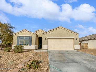 Tan house with two-car garage and desert landscaping at 41096 W Jenna Ln, Maricopa, AZ 85138