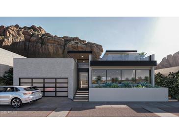 Contemporary home exterior boasts clean lines, modern design, glass garage door, and mountain views at 5761 N Echo Canyon Cir, Phoenix, AZ 85018