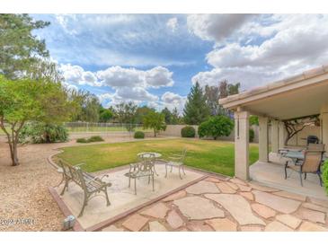 Spacious backyard with patio, grass, and mature trees at 6413 W Irma Ln, Glendale, AZ 85308