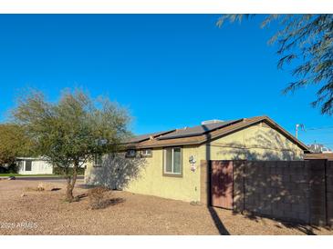 House exterior showcasing a well-maintained single story home with a spacious yard and solar panels at 14819 N Mauna Loa Ln, Phoenix, AZ 85053