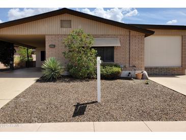 Charming home featuring a well-maintained front yard with desert landscaping and a covered carport at 2233 N Middlecoff Dr, Mesa, AZ 85215