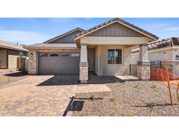 One-story home with gray exterior, stone accents, and a two-car garage at 31277 N 130Th Ave, Peoria, AZ 85383