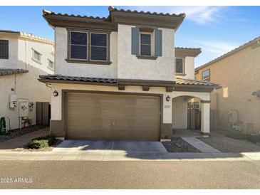 Two-story stucco home with a brown garage door and landscaped yard at 4738 E Tierra Buena Ln, Phoenix, AZ 85032