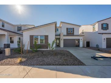 Contemporary two-story home featuring a two-car garage, modern windows, and low maintenance landscaping at 11029 E Ulysses Ave, Mesa, AZ 85212