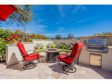 Outdoor patio with seating area, fire pit, and built-in grill at 1806 E Azafran Trl, Queen Creek, AZ 85140