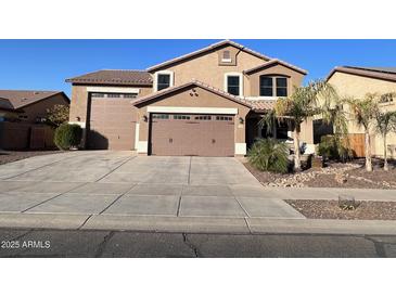 Two-story house with a three-car garage and landscaped front yard at 15936 W Canterbury Dr, Surprise, AZ 85379