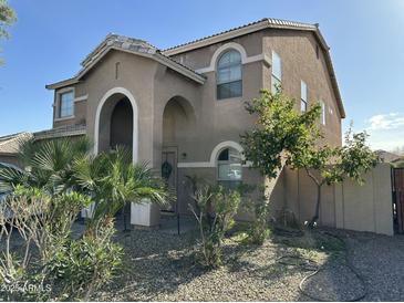 Two-story house with arched entryway, landscaping, and a light brown exterior at 10617 W La Reata Ave, Avondale, AZ 85392