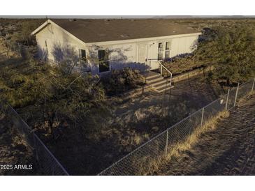 Aerial view of a ranch-style home with fenced yard and desert landscape at 12866 W Sun Ave, Eloy, AZ 85131