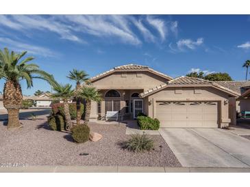 Single-story home with attractive landscaping and two-car garage at 14416 W Kiowa Trl, Surprise, AZ 85374