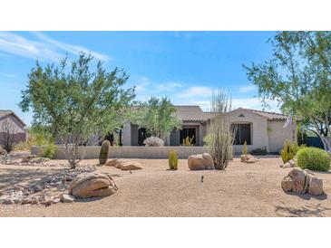 Desert landscaping surrounds this single-story home with a large driveway at 5701 E Hedgehog Pl, Scottsdale, AZ 85266