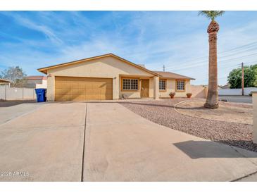 House exterior featuring a tan stucco finish, a two-car garage, and a well-manicured front yard at 6249 S Parkside Dr, Tempe, AZ 85283