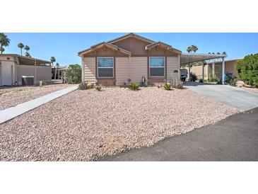 Tan two-bedroom house with carport and landscaped yard at 6722 W Taylor St # 294, Phoenix, AZ 85043