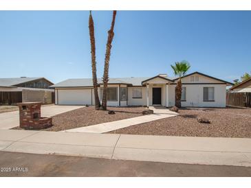 White single story home with a two car garage, landscaped yard, and walkway at 1527 W Rosemonte Dr, Phoenix, AZ 85027