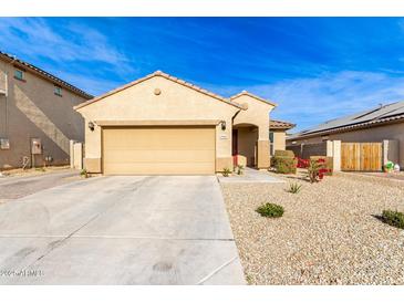 Tan house with a two-car garage and desert landscaping at 17662 W Daley Ln, Surprise, AZ 85387