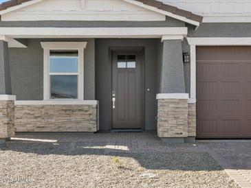 Inviting home entrance featuring a dark brown front door and stone accents at 17755 W Elm St, Goodyear, AZ 85395