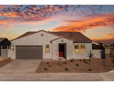 One-story home with gray stucco, brown roof, and a two-car garage at 18104 W Silverwood Dr, Goodyear, AZ 85338