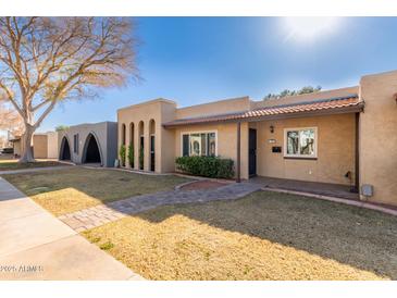 Tan stucco home with arched entryway and paved walkway at 1833 W Citrus Way, Phoenix, AZ 85015