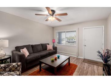 Comfortable living room featuring a ceiling fan, a cozy couch and a center table on top of an orange shag rug at 2235 W Villa Rita Dr, Phoenix, AZ 85023