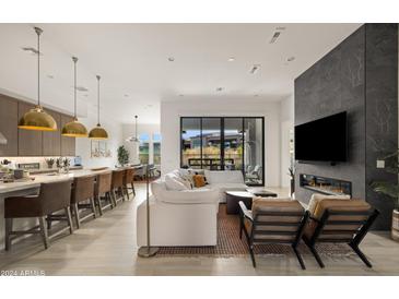 Open living room with modern fireplace and kitchen views at 23491 N 125Th Pl, Scottsdale, AZ 85255