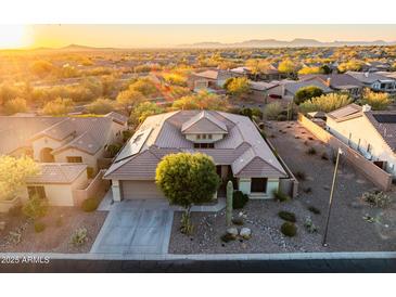 Aerial view of single-story house with desert landscaping, and community in background at 40822 N Harbour Town Way, Anthem, AZ 85086