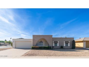 Ranch style home with brick exterior, attached garage, and landscaped front yard at 14202 N Lakeforest Dr, Sun City, AZ 85351