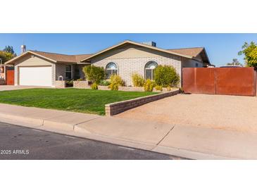 Single story home with attached garage, landscaped lawn, and gated driveway at 1638 E Hackamore St, Mesa, AZ 85203