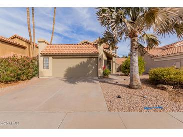 Tan two-story house with a brown tile roof, attached garage, and desert landscaping at 1740 W Del Rio St, Chandler, AZ 85224