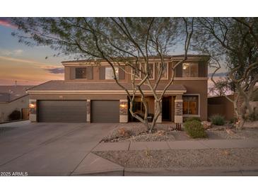 Two-story house with a large front yard, two-car garage, and mature trees at 2602 W Trapanotto Rd, Phoenix, AZ 85086