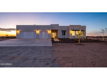 Stunning desert contemporary home with three-car garage and landscaped front yard at 29456 N 208Th Ln, Wittmann, AZ 85361