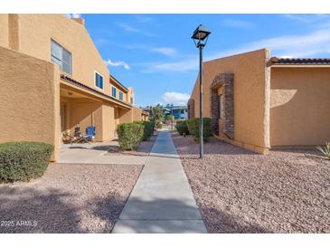 Neat pathway leads to the condo building, with manicured landscaping at 3511 E Baseline Rd # 1243, Phoenix, AZ 85042