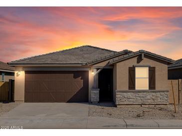 Charming single-story home featuring a two-car garage, stone accents, and a well-maintained front yard at 37042 W Prado St, Maricopa, AZ 85138