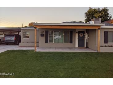 Cute bungalow with a covered porch, grassy lawn, and carport at 416 N Orange --, Mesa, AZ 85201