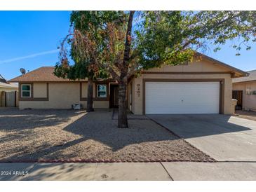 Single story home with a two-car garage and gravel landscaping at 6207 W Acoma Dr, Glendale, AZ 85306