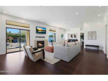 Bright living room features hardwood floors, fireplace, and access to backyard at 7687 E Wing Shadow Rd, Scottsdale, AZ 85255