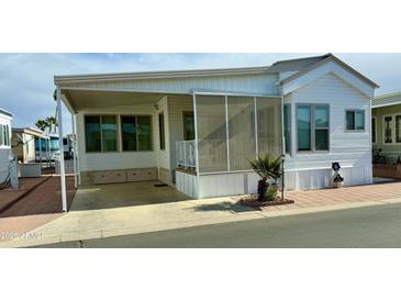 White single-wide manufactured home with covered porch and screened patio at 7750 E Broadway Rd # 232, Mesa, AZ 85208