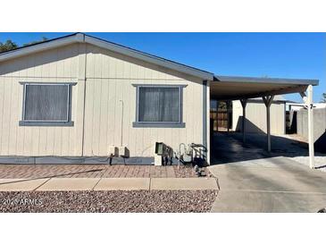 Tan single-wide manufactured home with carport and paved driveway at 11275 N 99Th Ave # 7, Peoria, AZ 85345